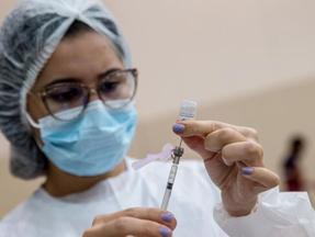 enfermeira manuseando seringa com vacina